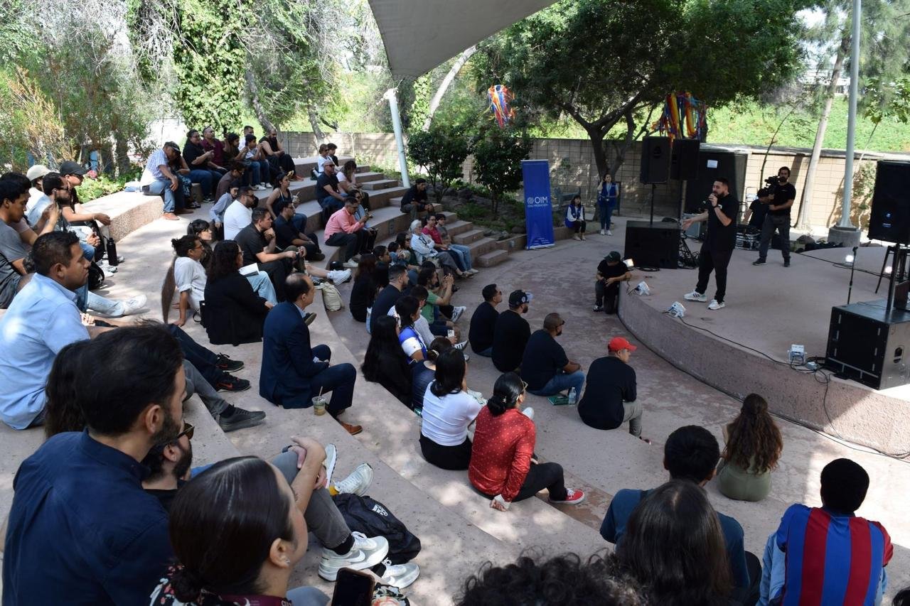 Danger AK impartiendo un taller de rap ante un público sentado en las gradas de un foro al aire libre